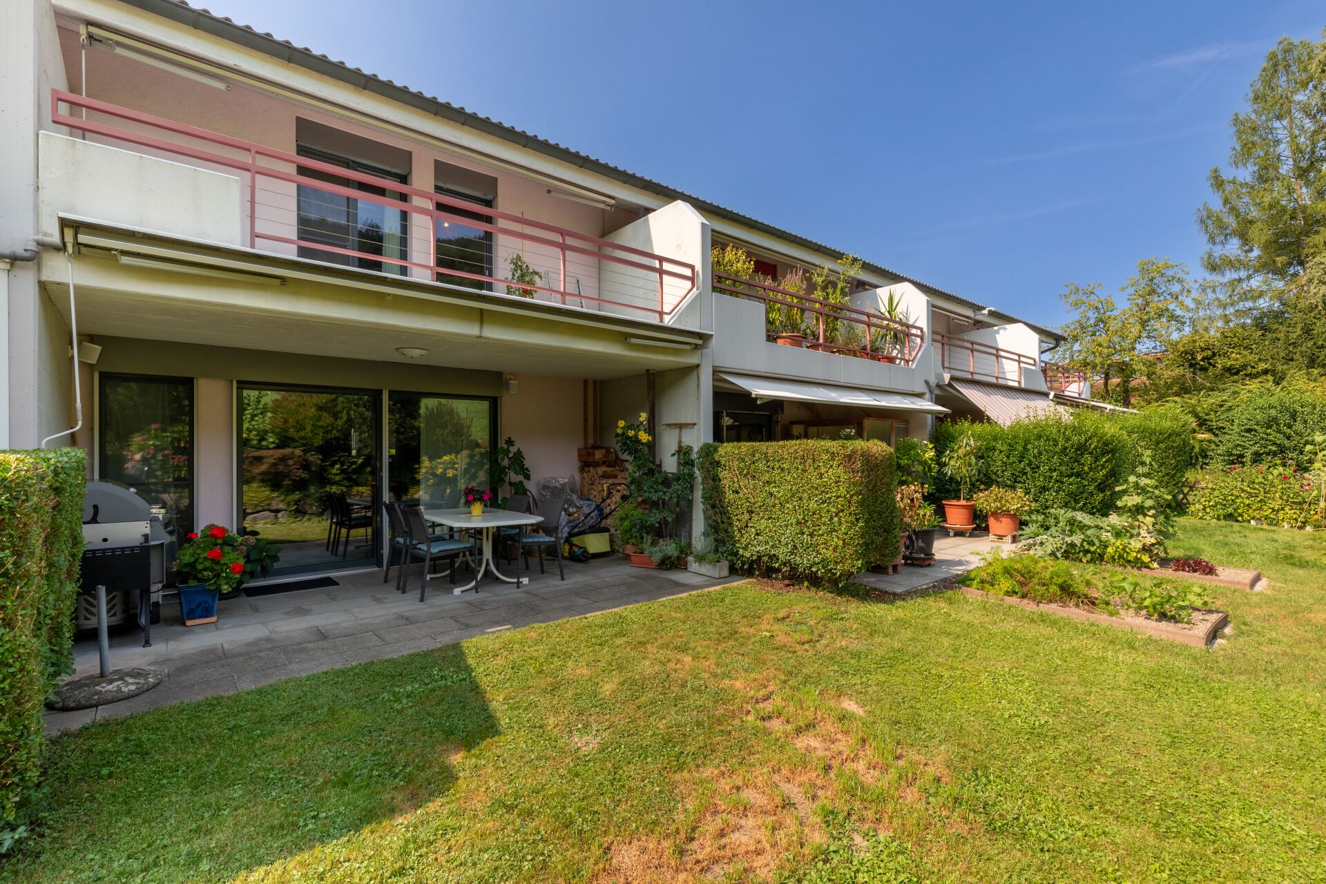 Das Reihenhaus mit seinem Gartensitzplatz und dem Balkon im Obergeschoss (Ausrichtung gegen Südosten)